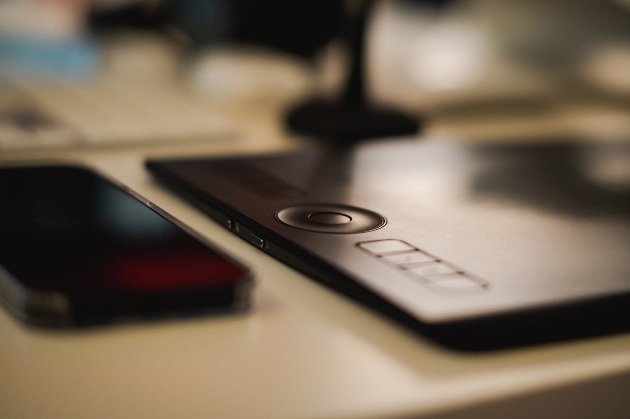 Close-up of a graphic tablet and smartphone on a designers desk, emphasizing modern technology and creativity.